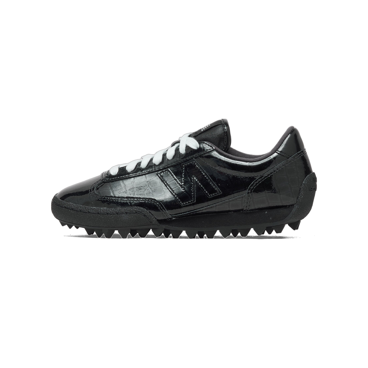 Side view of a black patent leather New Balance sneaker with white laces, a glossy N logo, and a textured black lug sole, toe pointing left.