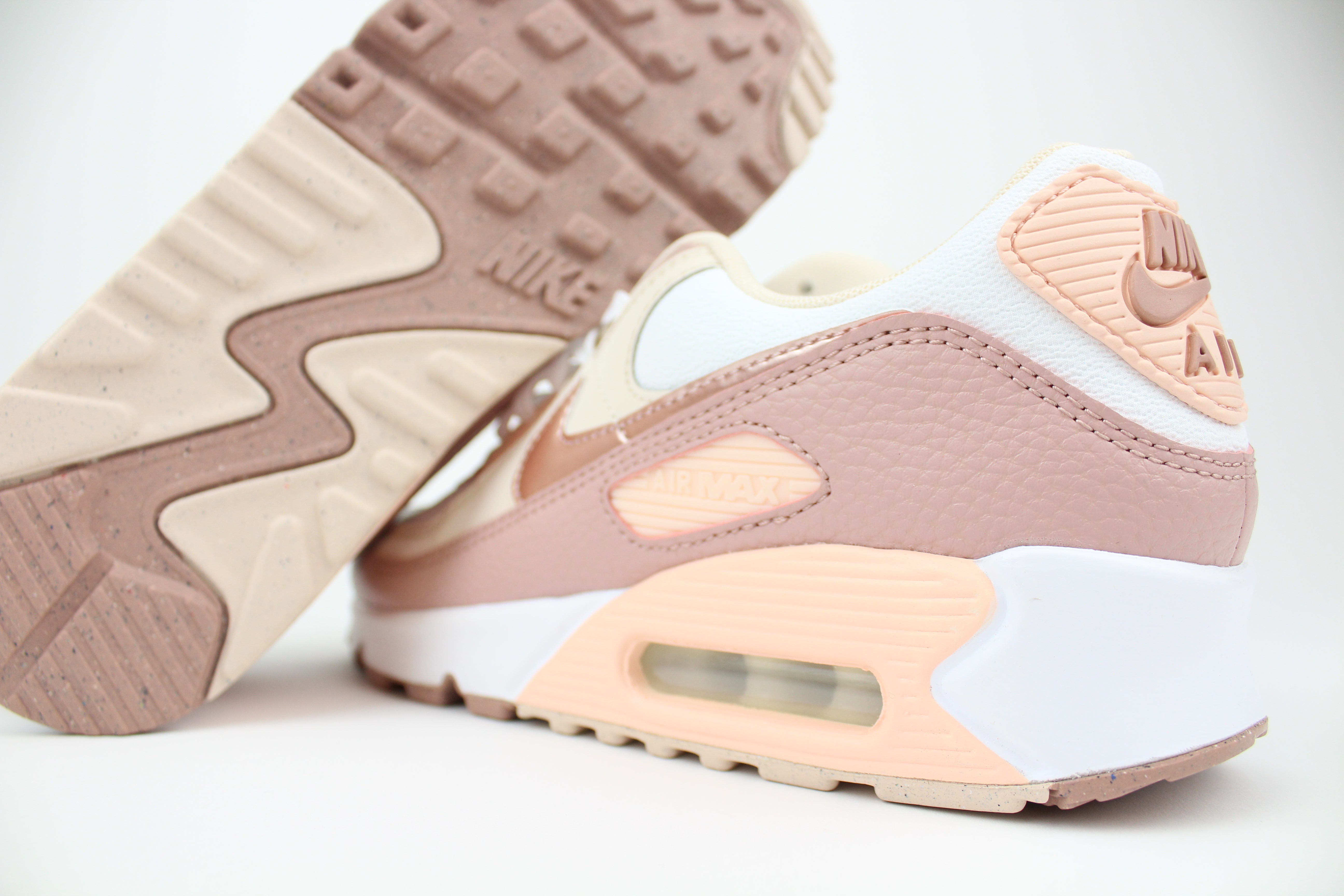 Eco‑friendly Air Max 90 in “Washed Coral” & “Particle Pink” with visible Air cushioning. Limited July 2025 release. Shop now at The Attic!