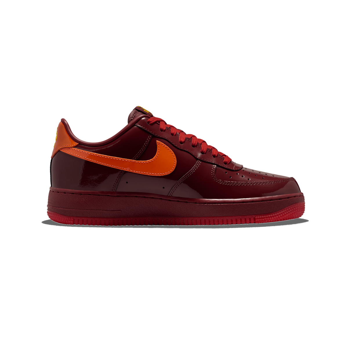 Side view of a dark red patent leather Nike Air Force 1 low-top sneaker with an orange Swoosh and red laces, toe pointing left.