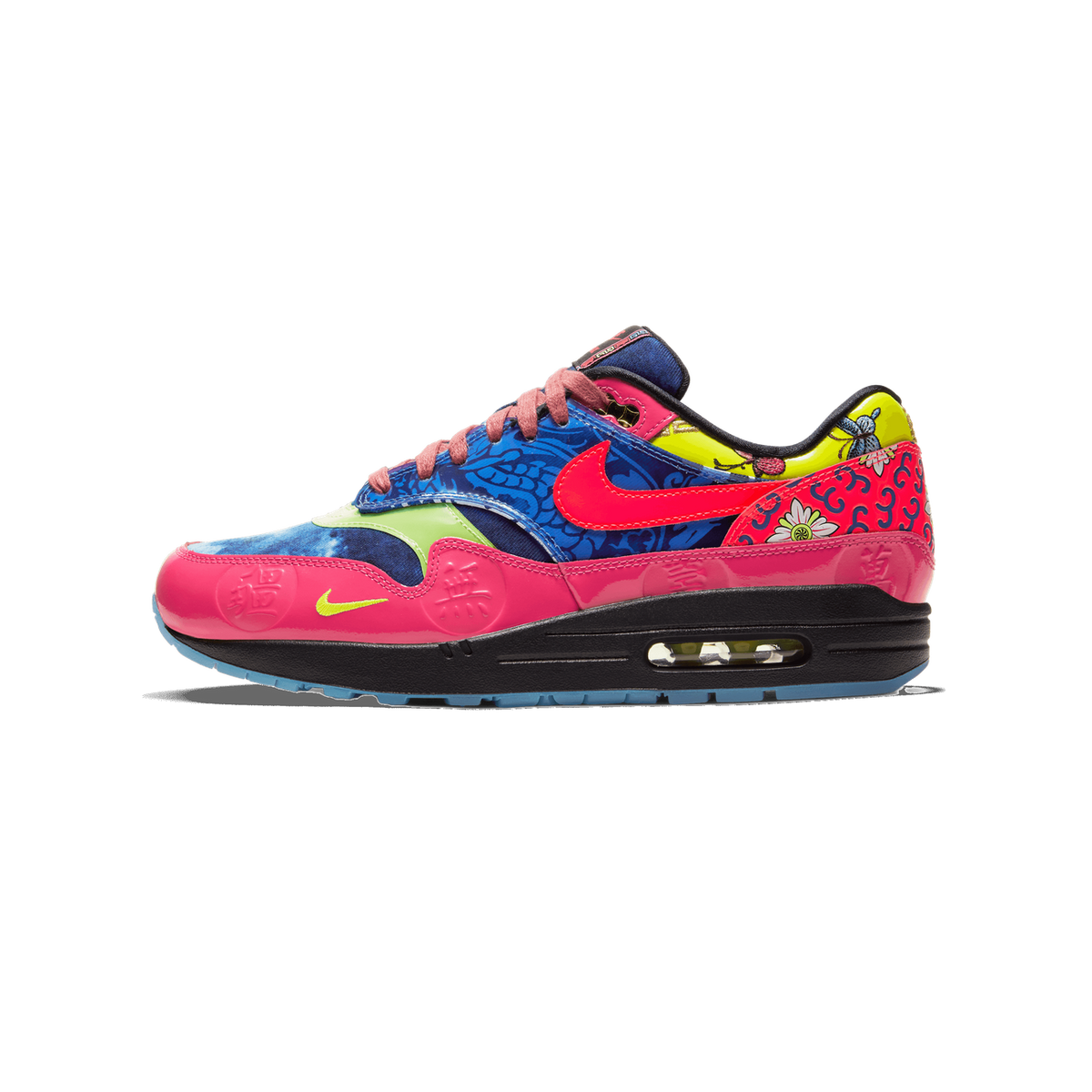 Lateral view of a Nike Air Max 1 sneaker with a multicolor patchwork design featuring blue floral print, pink patent leather toe and heel with embossed Chinese characters, a yellow insect-print panel, a pink Swoosh, and a visible Air cushion unit in