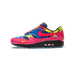 Lateral view of a Nike Air Max 1 sneaker with a multicolor patchwork design featuring blue floral print, pink patent leather toe and heel with embossed Chinese characters, a yellow insect-print panel, a pink Swoosh, and a visible Air cushion unit in