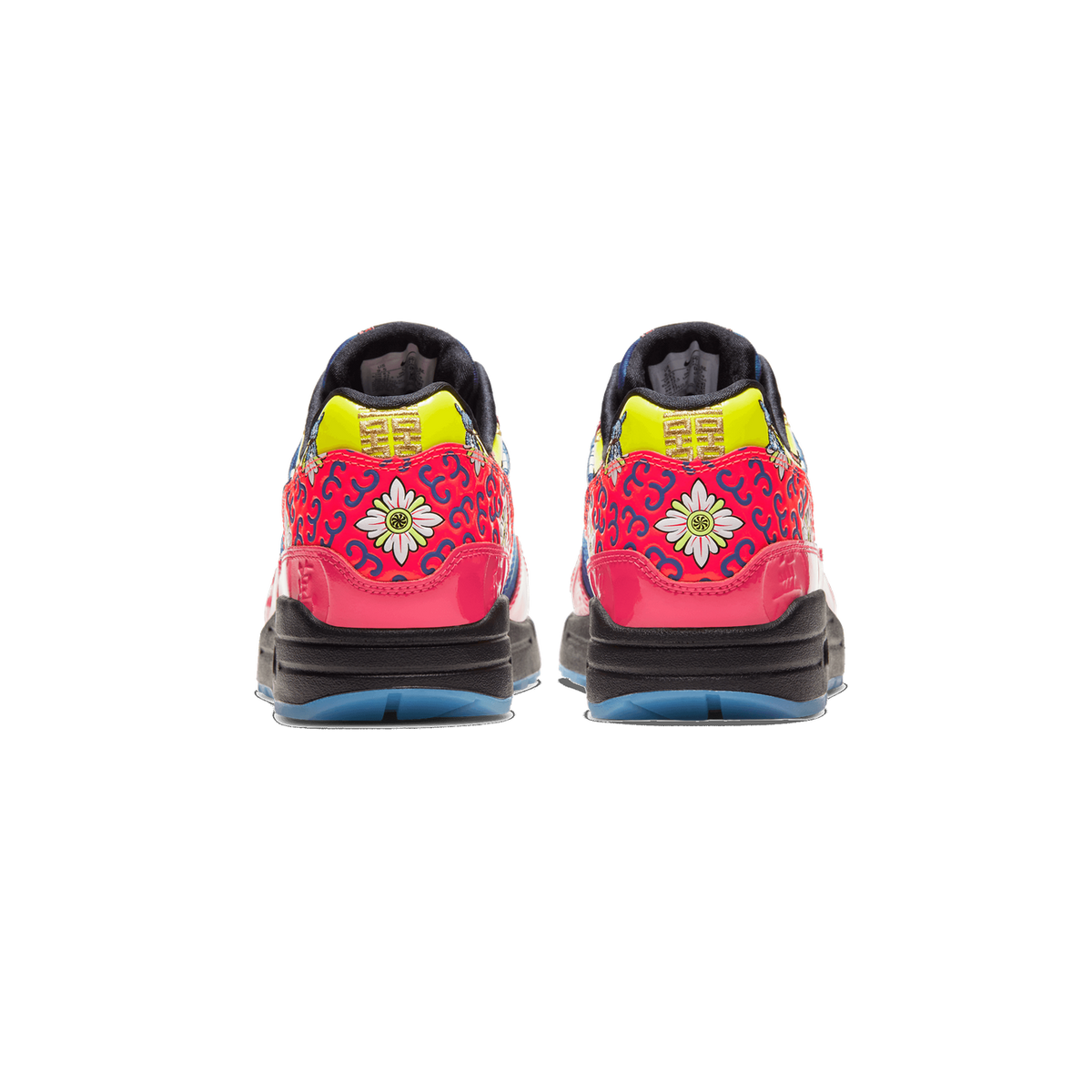 Rear view of a pair of Nike Air Max 1 Chinese New Year sneakers showing red heel panels with blue floral patterns, gold characters on yellow-green trim, pink accents, and black soles with blue translucent outsoles.