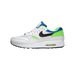 Side view of a white Nike Air Max 1 sneaker with a black swoosh, green accents, and blue heel tab, toe pointing left