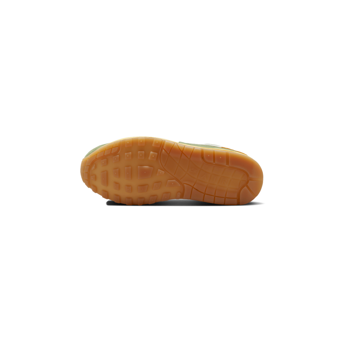 Underside of a sneaker showing a gum-brown rubber outsole with a pattern of square lugs and a visible Air unit window, with green and yellow suede upper edges visible at the sides.