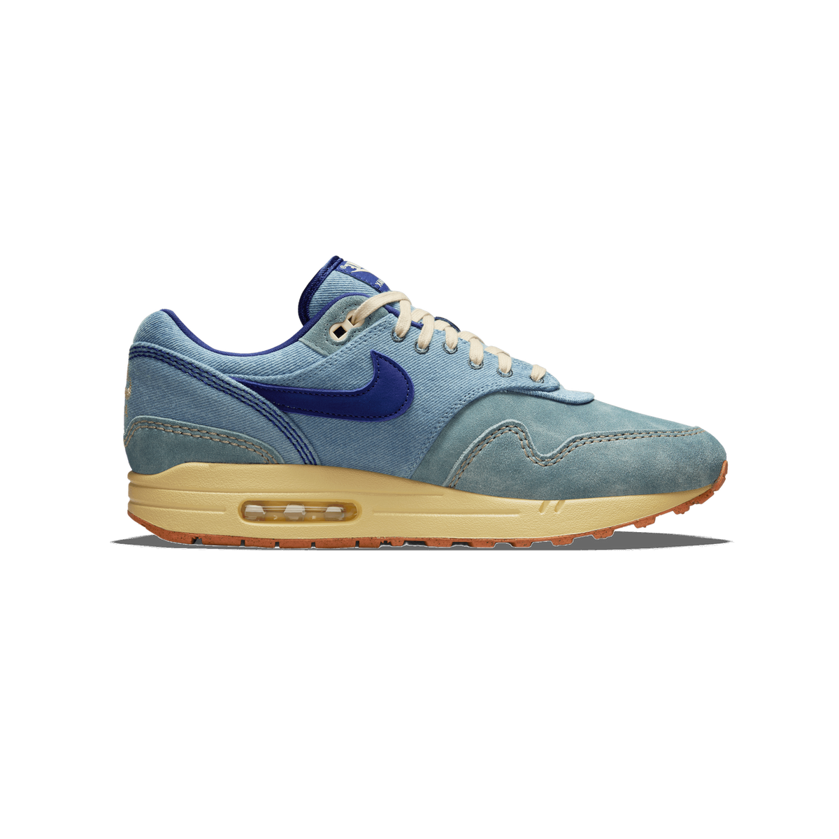 Left Nike Air Max 1 sneaker in denim-blue suede and canvas with a navy swoosh and tan midsole, shown from the outside with toe pointing left.