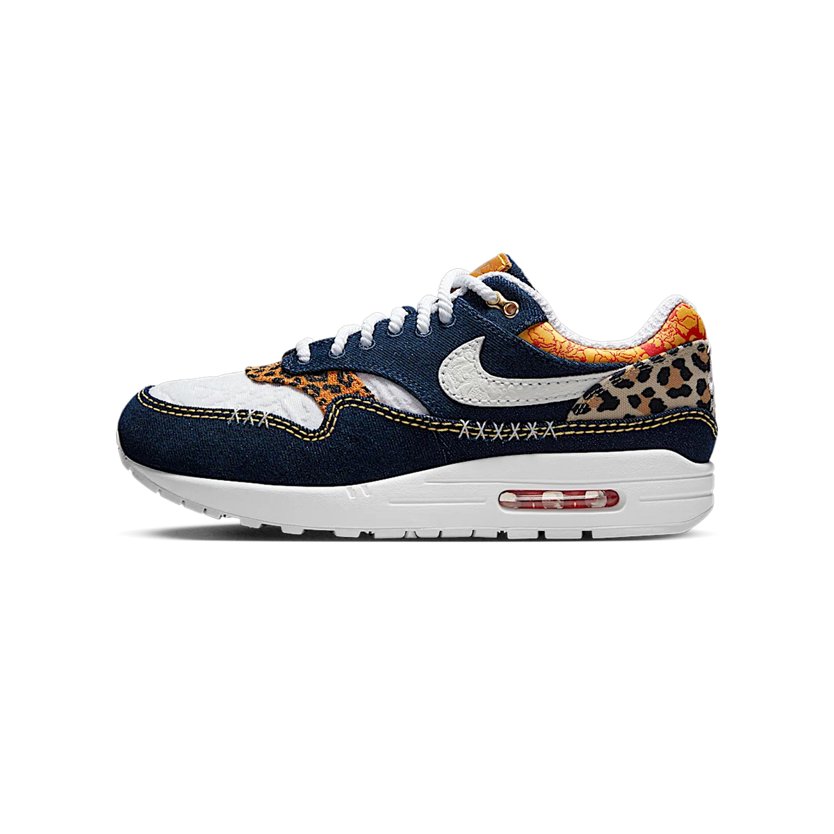 Left shoe outer side view of a Nike Air Max 1 Premium in denim blue with white swoosh, leopard print panels, and yellow accents, toe pointing left