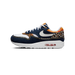 Left shoe outer side view of a Nike Air Max 1 Premium in denim blue with white swoosh, leopard print panels, and yellow accents, toe pointing left