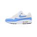 Side view of a white and blue Nike Air Max 1 sneaker with a blue swoosh logo, cream overlays, and visible Air unit in the sole, toe pointing left.