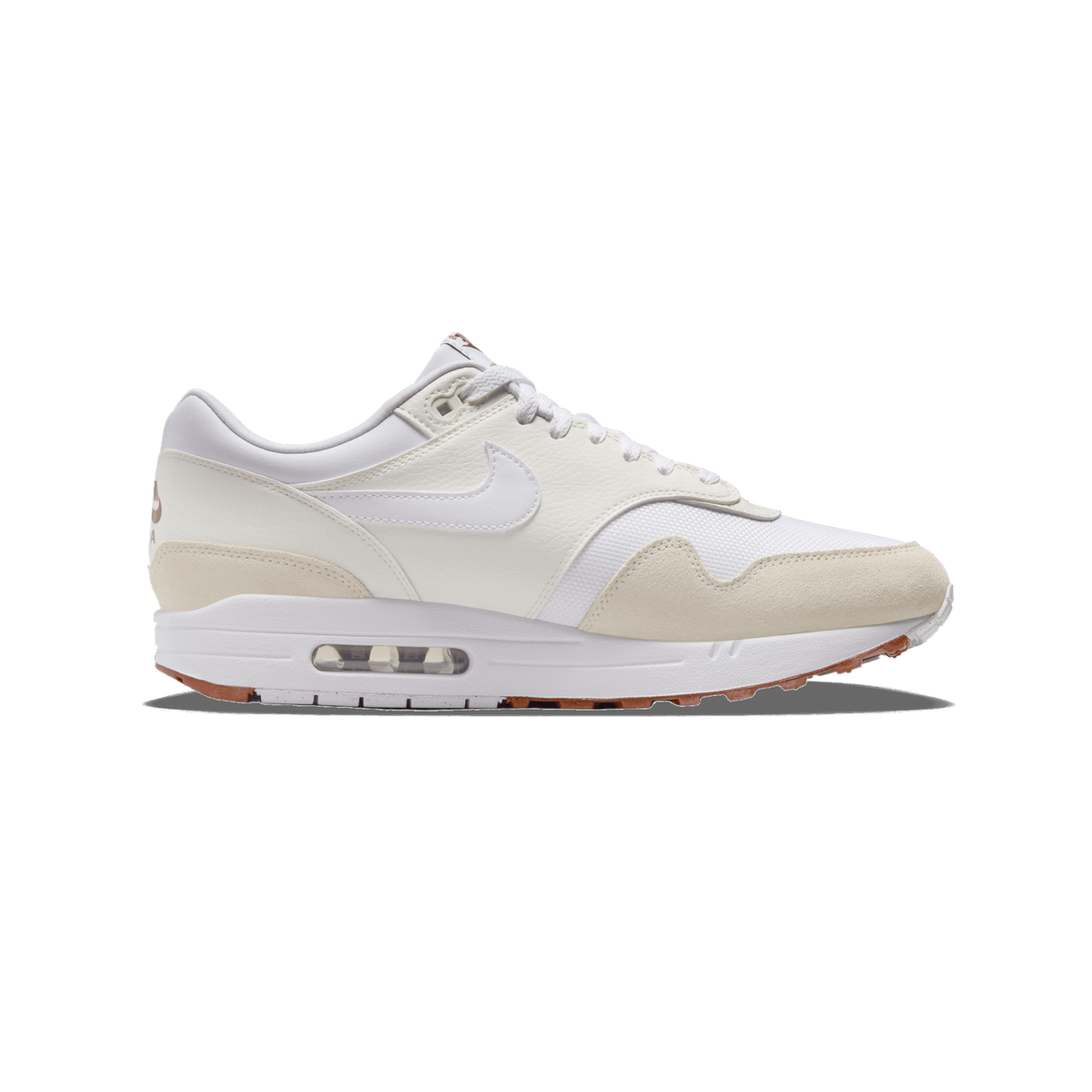 Side profile of a white and beige Nike Air Max 1 SC sneaker with the toe pointing left, showing white and sail leather overlays, a white Swoosh, beige suede toe and heel panels, and a visible Air unit in the midsole.