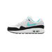 Left Nike Air Max 1 sneaker facing left, showing white and grey upper with jade green swoosh, black midsole, and purple lace accents visible near the collar.