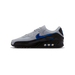 Left Nike Air Max 90 sneaker in grey, black, and blue with a carbon-fiber-textured heel and toe box, shown from the lateral side with toe pointing left.