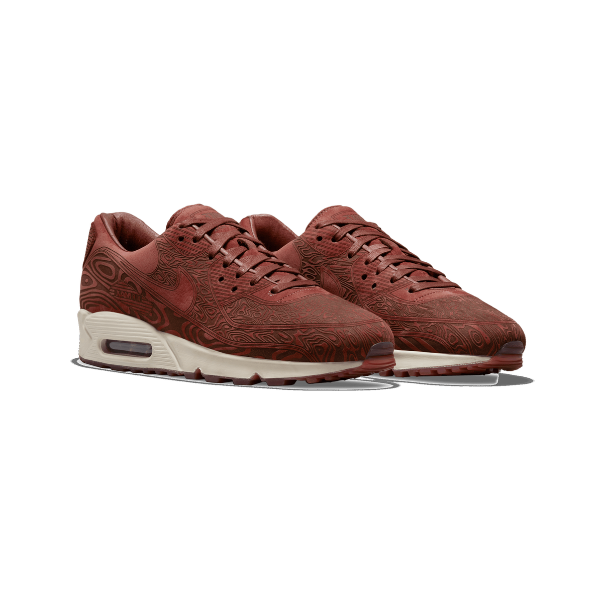 A pair of Nike Air Max 90 sneakers in a deep reddish-brown laser-etched topographic pattern with cream-colored midsoles and visible Air unit, shown side by side angled to the left.
