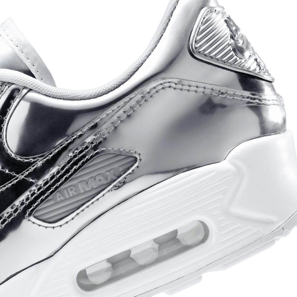Close-up of a Nike Air Max 90 in metallic silver showing the heel, visible Air unit, and Air Max branding on the side panel.