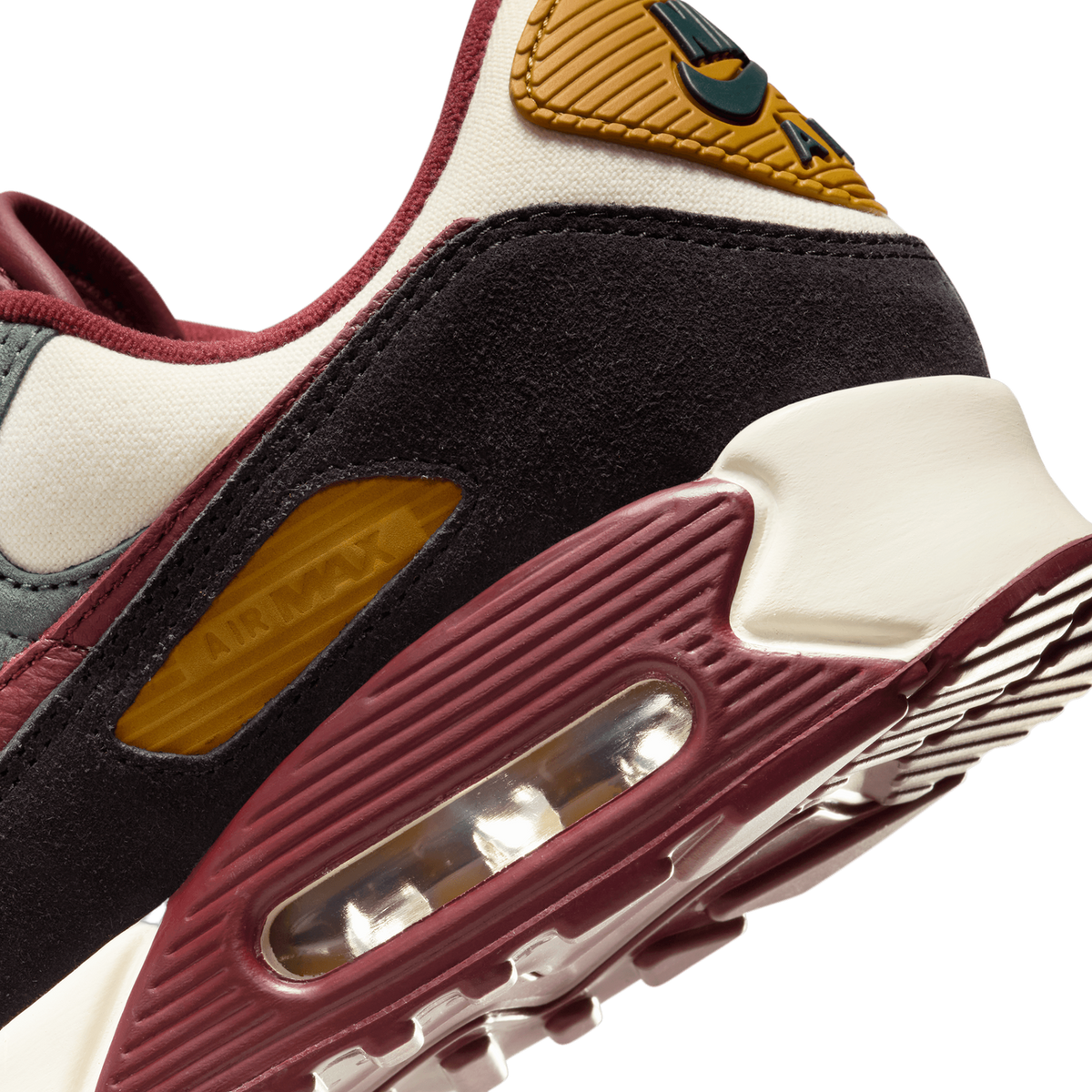 Close-up of the heel and visible Air Max bubble on a Nike Air Max 90 sneaker in cream, black, maroon, and mustard yellow colors.