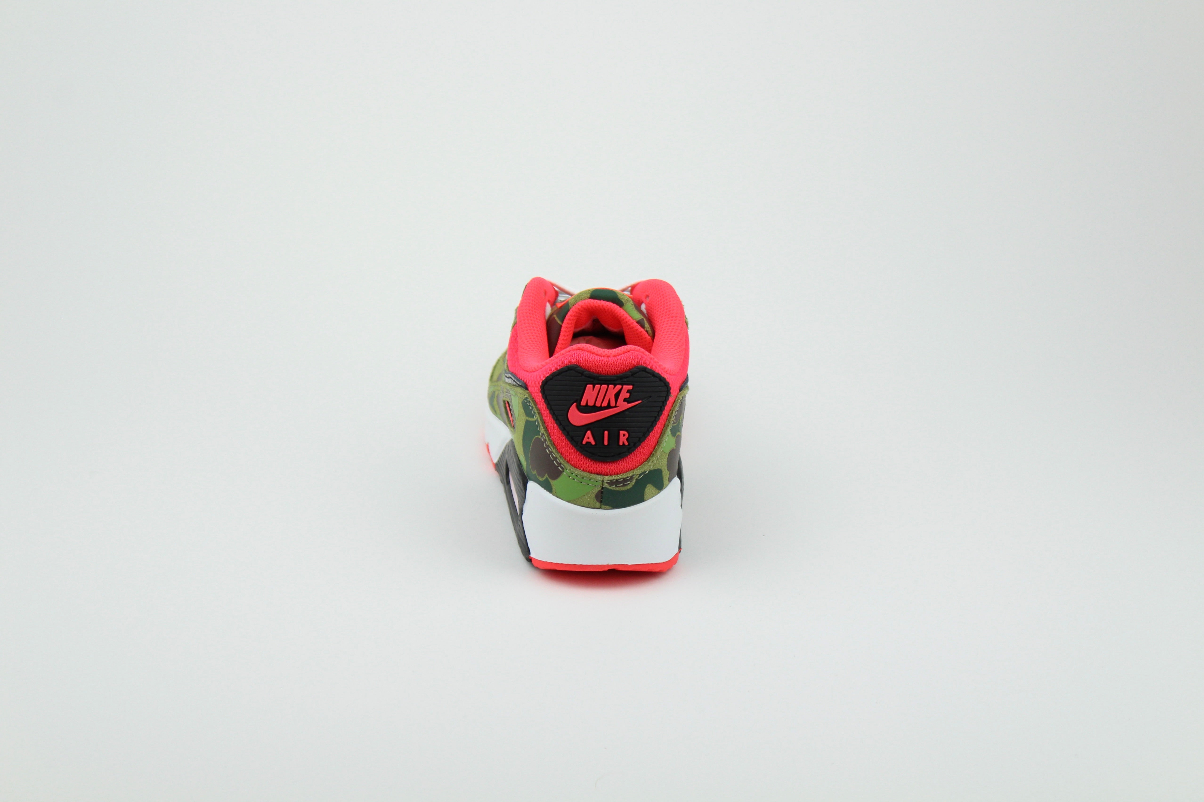 Close-up of Nike Air Max 90 'Reverse Duck Camo' sneaker, featuring bold reverse camo pattern, vibrant color accents, and signature Air cushioning, ideal for fashion-forward sneaker enthusiasts and collectors.