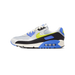 Side view of a gray Nike Air Max 90 sneaker with blue accents, a yellow-green Swoosh logo, black heel, and visible Air cushioning in the sole.