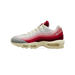 Left Nike Air Max 95 sneaker shown from the outside with toe pointing left, featuring layered red, pink, grey and white panels with a cream midsole and visible Air unit in the heel.