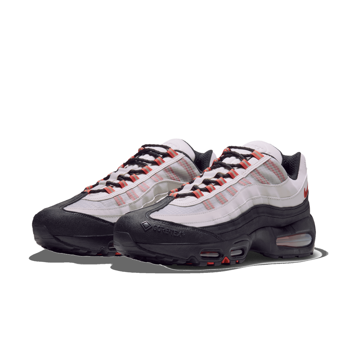 Pair of Nike Air Max 95 GORE-TEX sneakers in white and black with orange accents and black toe caps, angled toward the left