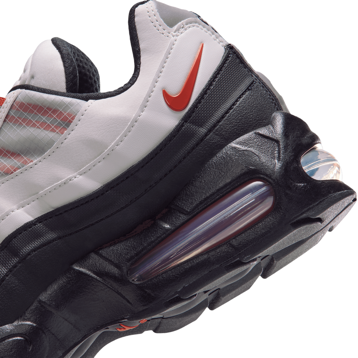Close-up rear angle of a white and black Nike Air Max 95 showing the orange swoosh logo and visible air cushioning unit in the heel.