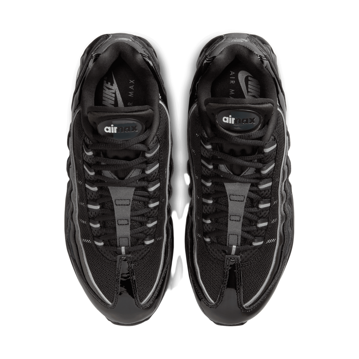 Top-down view of a pair of black patent leather Nike Air Max 95 sneakers placed side by side with toes pointing up, showing the laces, tongues with airmax branding, and glossy bubbled midsole panels.