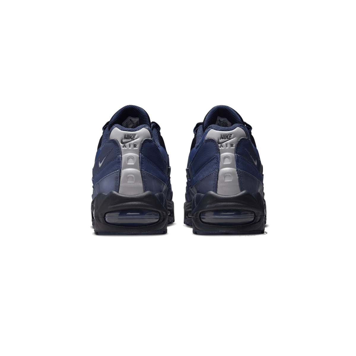 Rear view of a pair of navy blue Nike Air Max 95 sneakers with silver heel tabs bearing the Nike Air logo, black midsoles, and visible air units at the heels.