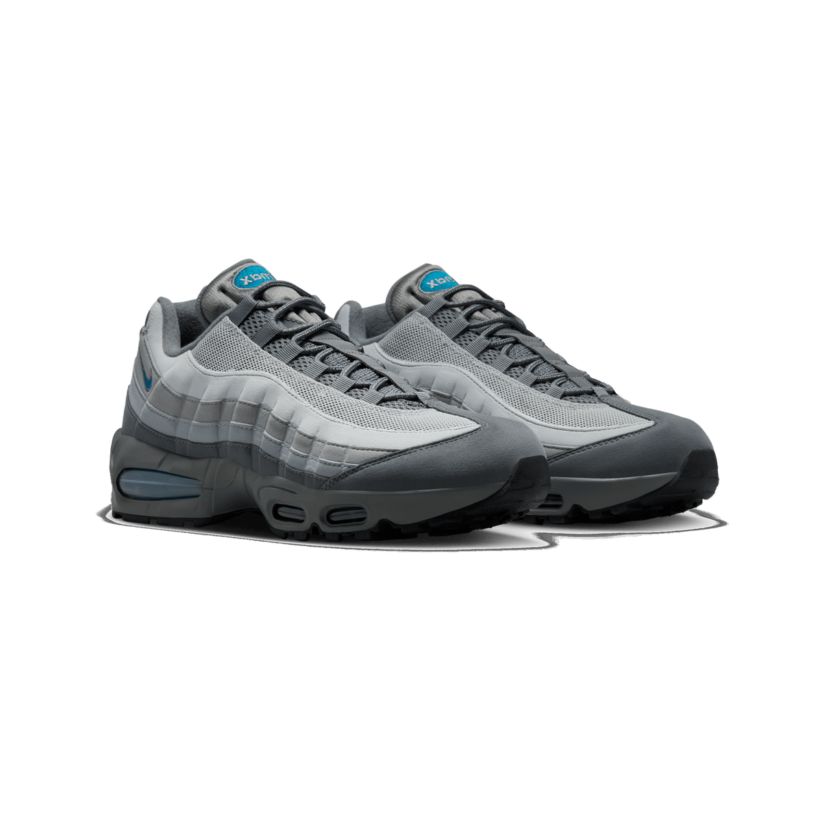 A pair of grey Nike Air Max 95 sneakers angled side by side, showing light grey mesh panels, dark grey suede overlays, teal-blue Swoosh and Air Max tongue tags, and visible teal Air unit in the heel.