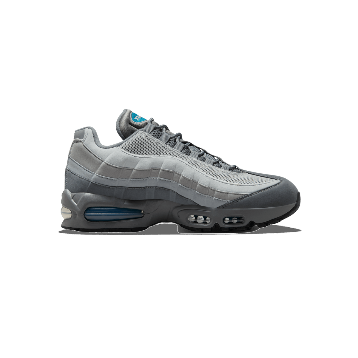 Side profile of a grey Nike Air Max 95 sneaker with the toe pointing left, showing layered grey suede and mesh panels, a teal Nike logo on the tongue, and visible blue-tinted Air units in the midsole.