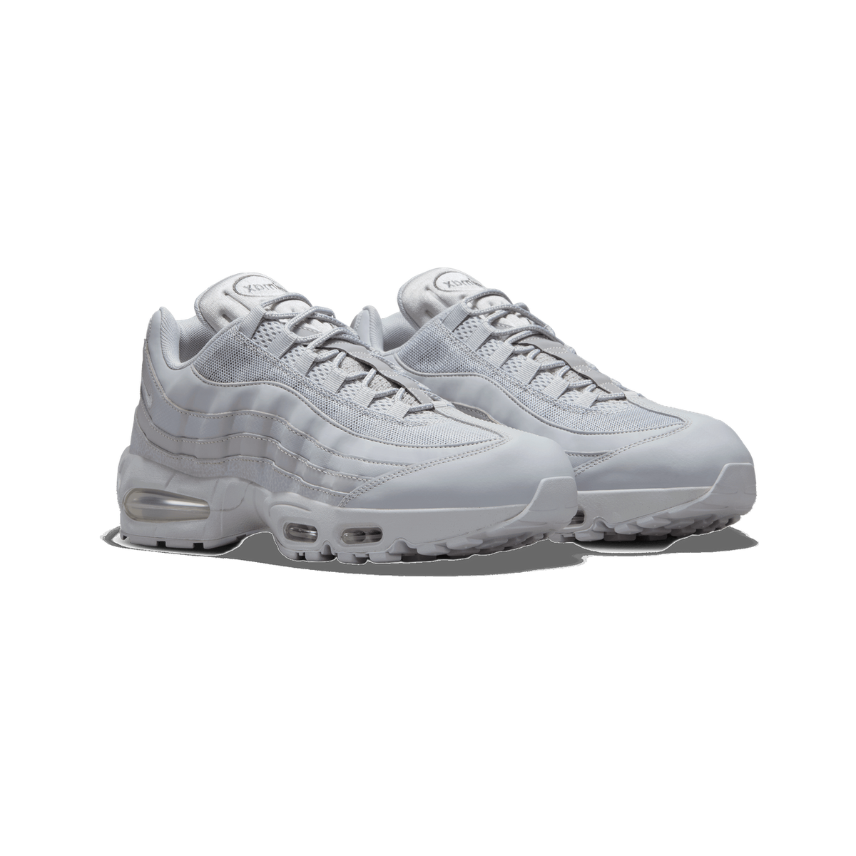 A pair of light grey Nike Air Max 95 sneakers shown side by side at a three-quarter angle, with visible Air units in the midsoles and the Air Max logo on the tongue tabs.