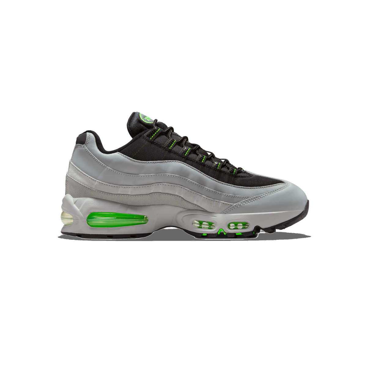 Side profile of a single Nike Air Max 95 sneaker with the toe pointing left, showing light grey leather overlays, black mesh upper, and bright green accents on the laces, eyelet tags, and visible Air units in the midsole.
