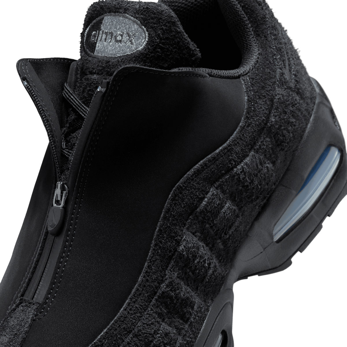 Close-up view of the black Nike Air Max 95 Zip SP showing the zipper closure, fuzzy textured overlays, and visible Air Max heel unit with blue tint window