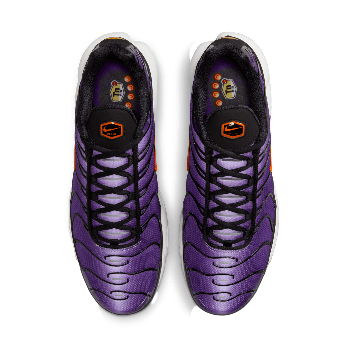 Top-down view of a pair of purple and black Nike Air Max Plus sneakers with orange accents, black laces, and white Tn Air branded insoles.