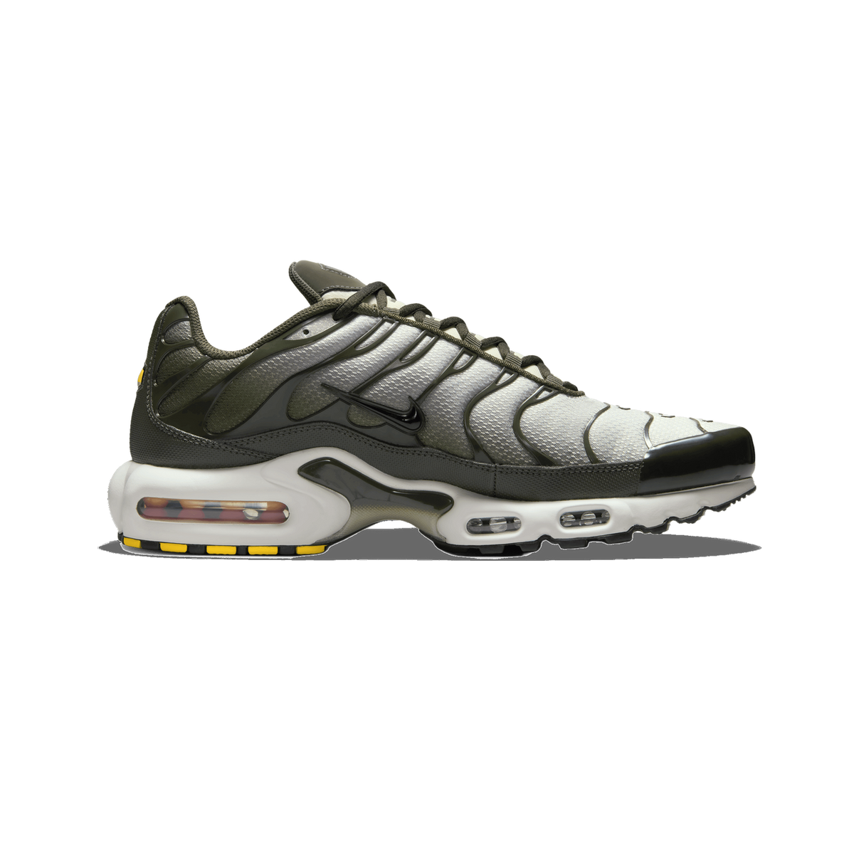 Side profile of a single Nike Air Max Plus sneaker with the toe pointing left, showing dark olive-green overlays, a light grey-white mesh upper, a black Swoosh on the side, and a white midsole with visible Air units and yellow accents on the heel.