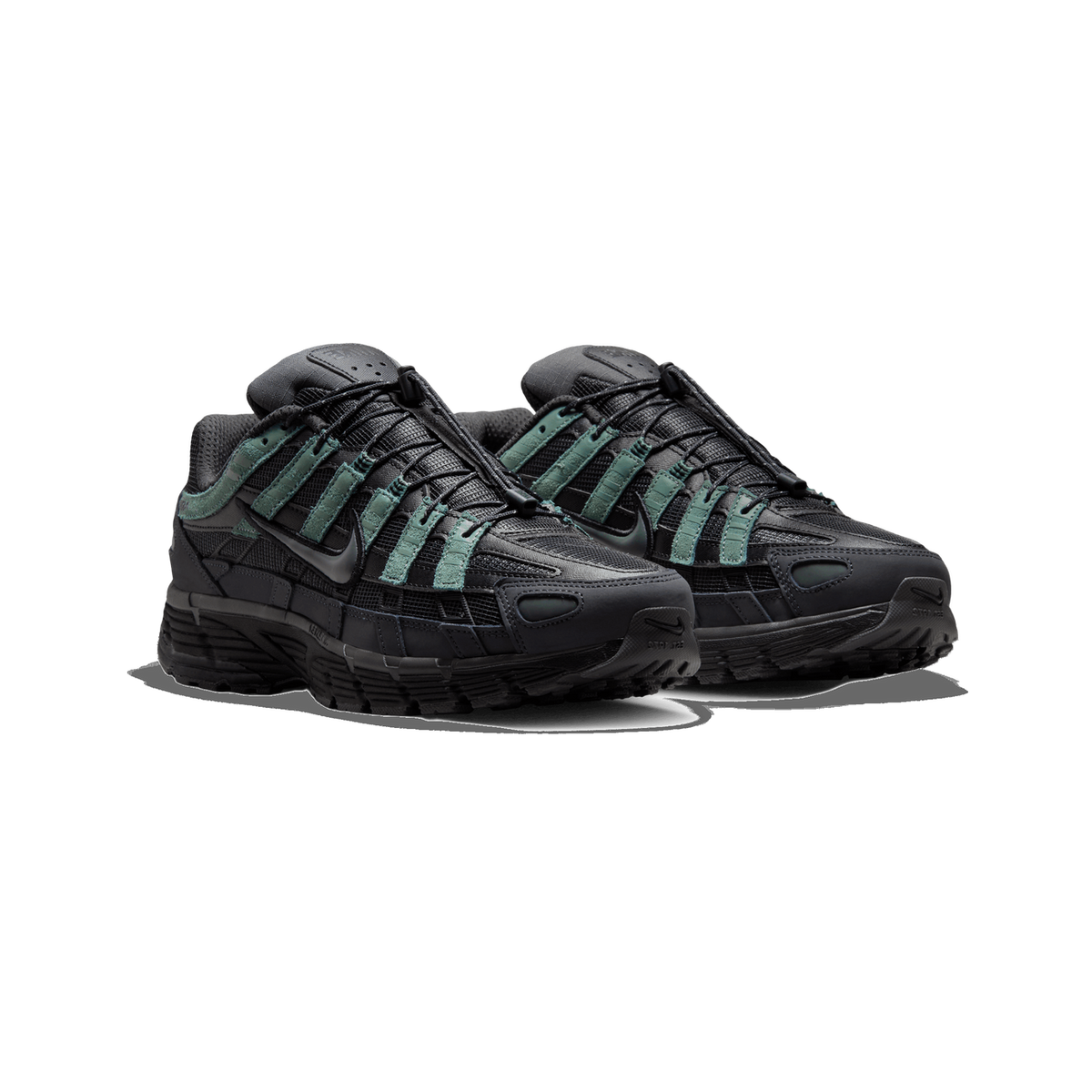 A pair of dark gray and black Nike P-6000 sneakers with green suede overlays, shown side by side angled toward the left on a white background.