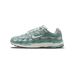 Side profile of a single Nike P-6000 sneaker with the toe pointing left, showing sage-green leather overlays, light grey mesh panels, a white swoosh logo and 'P-6000' lettering on the heel, and a cream-colored midsole.
