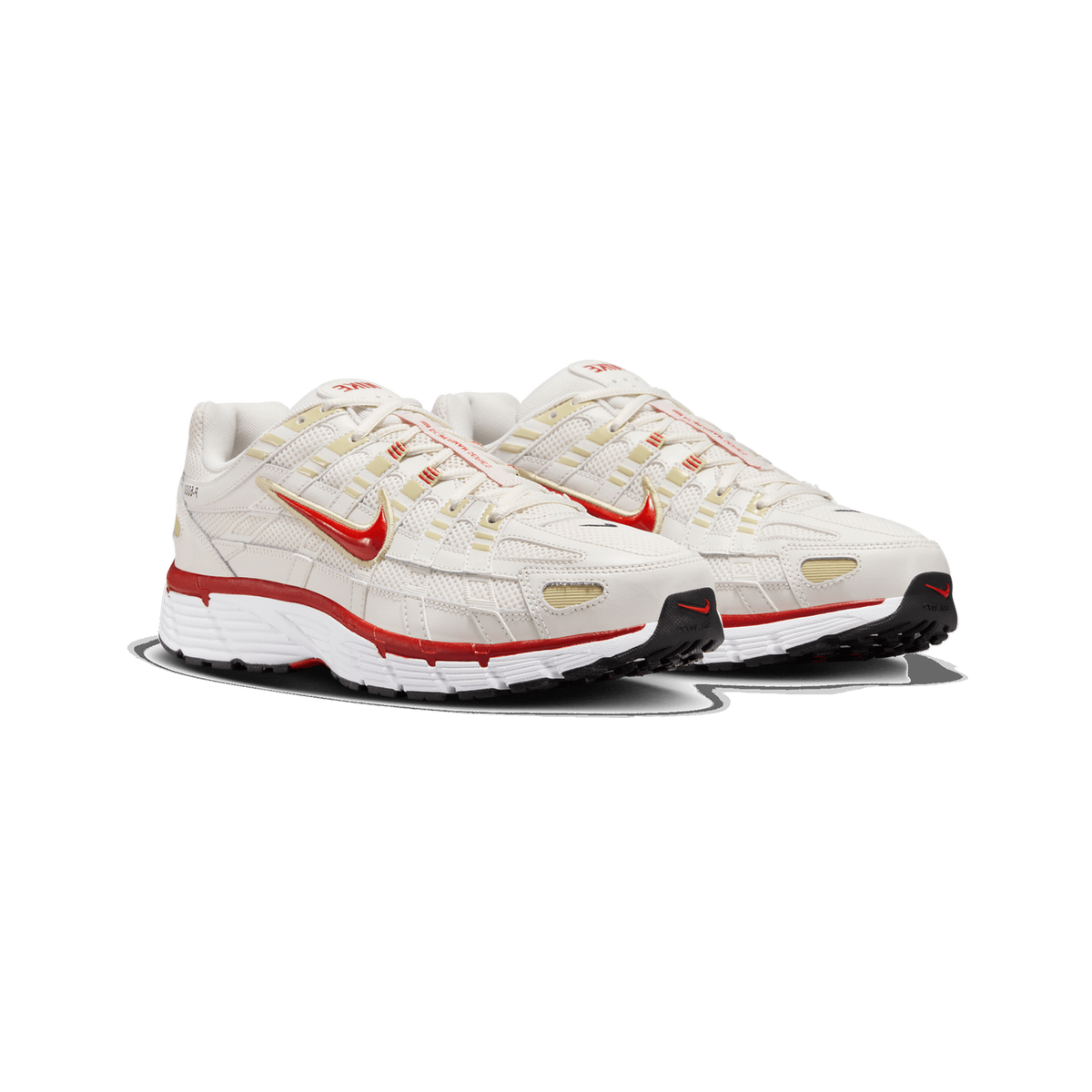 A pair of cream and white Nike P-6000 sneakers angled side by side, showing red Swoosh logos, red accents on the midsole, and black heel and toe details.
