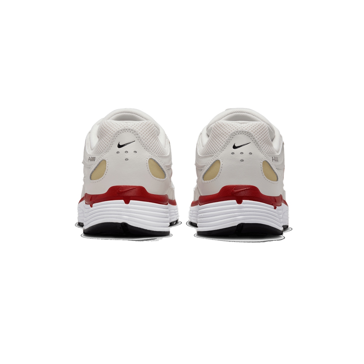 Rear view of a pair of white Nike P-6000 sneakers with red heel accents, tan side panels, black Nike swoosh logos on the heel tabs, and white soles with red and black detailing.