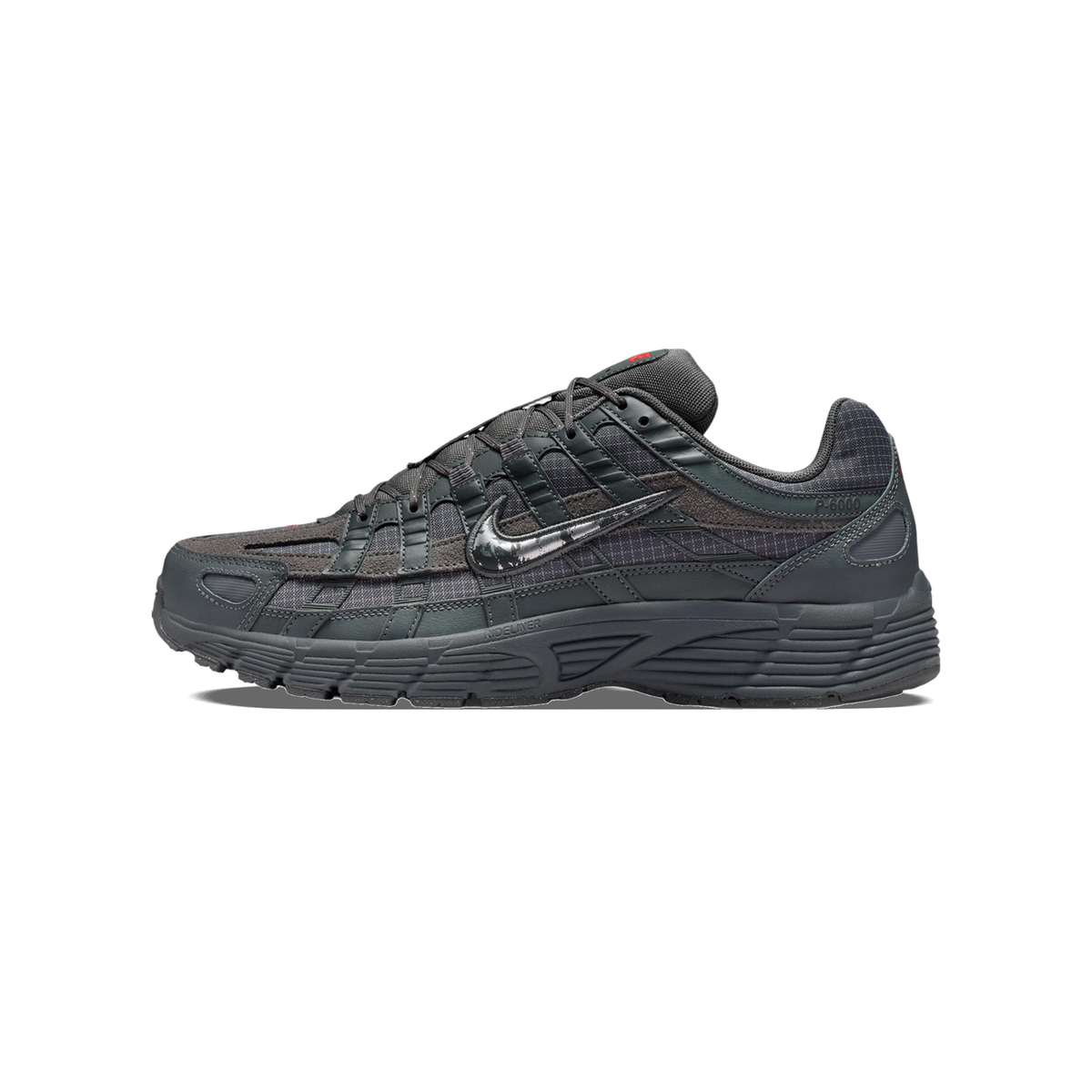 Side view of a dark grey Nike P-6000 sneaker with a metallic silver swoosh, textured panels, and a chunky ridged outsole, toe pointing left.