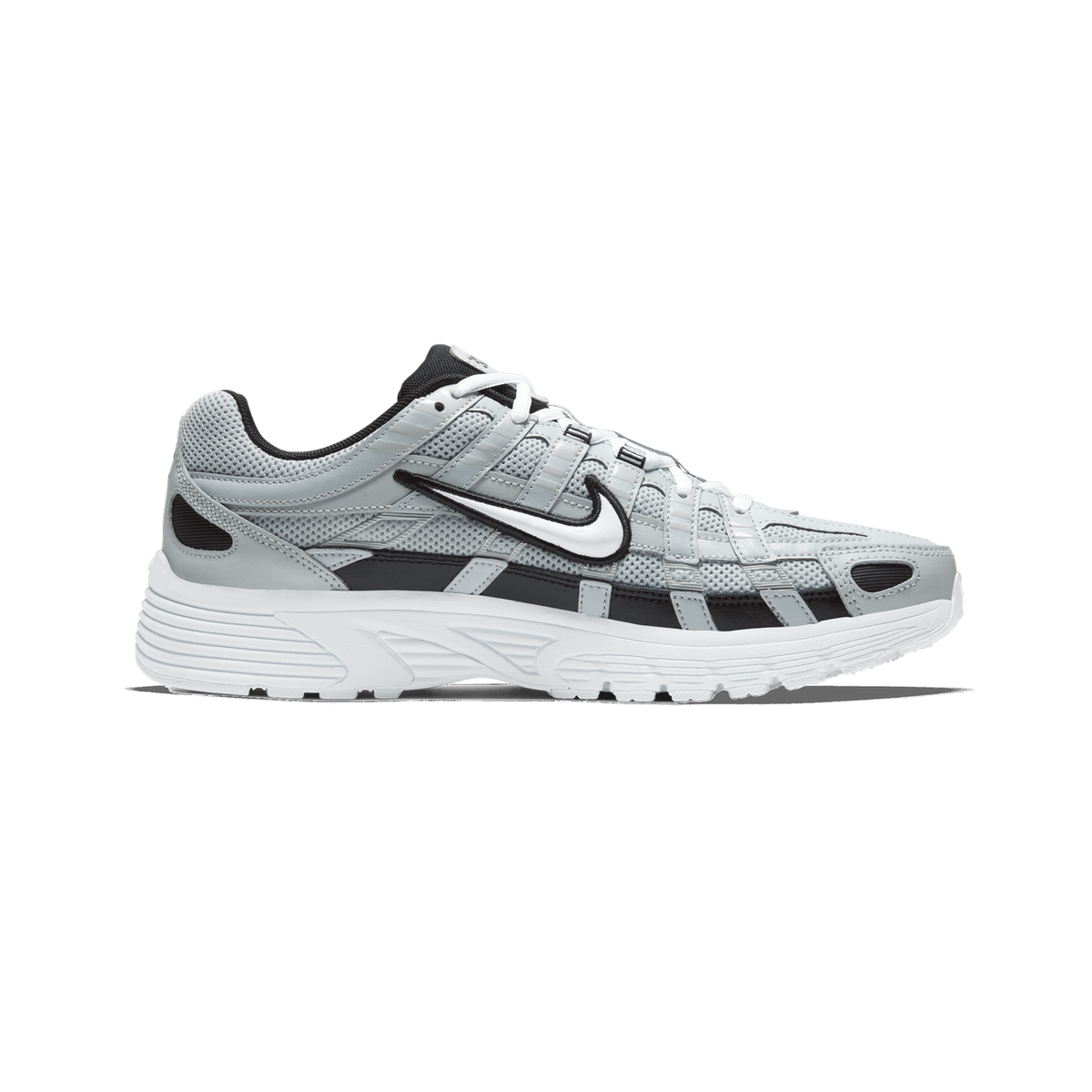 Side profile of a Nike P-6000 sneaker with toe pointing left, showing light grey mesh and leather upper, black and white Swoosh logo, black accents, and a white rubber midsole and outsole.