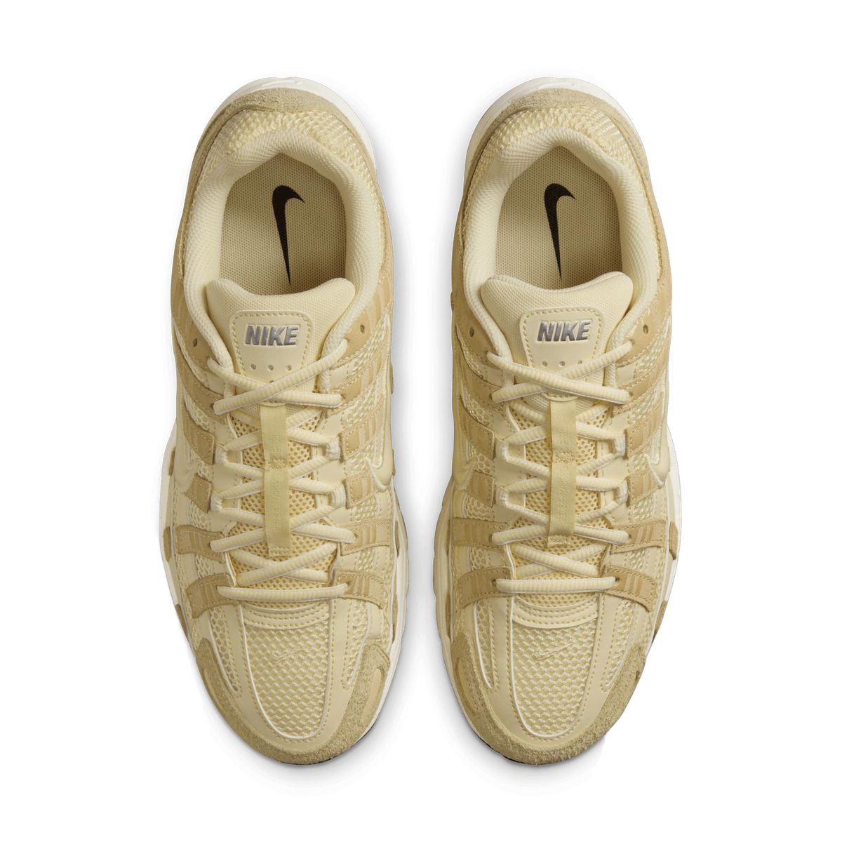 Overhead top-down view of a pair of beige and cream Nike P-6000 sneakers placed side by side, showing laces, tongues with Nike branding, and mesh and suede overlays.