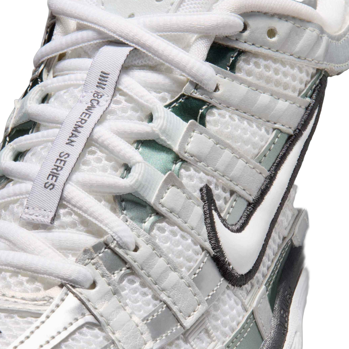 Close-up of a white Nike P-6000 sneaker showing the mesh upper, laces, side Swoosh with dark outline, and a woven pull tab labeled Bowerman Series