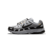 Left side profile of a grey and black Nike P-6000 sneaker with the toe pointing left, showing the large black Swoosh logo, a black-and-yellow-orange 'P-6000' label on the heel, and an elastic lace-cord closure.