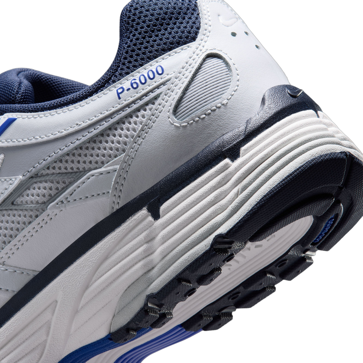 Close-up of the heel and midsole of a white and navy Nike P-6000 sneaker showing the ridged midsole and P-6000 text on the heel panel.