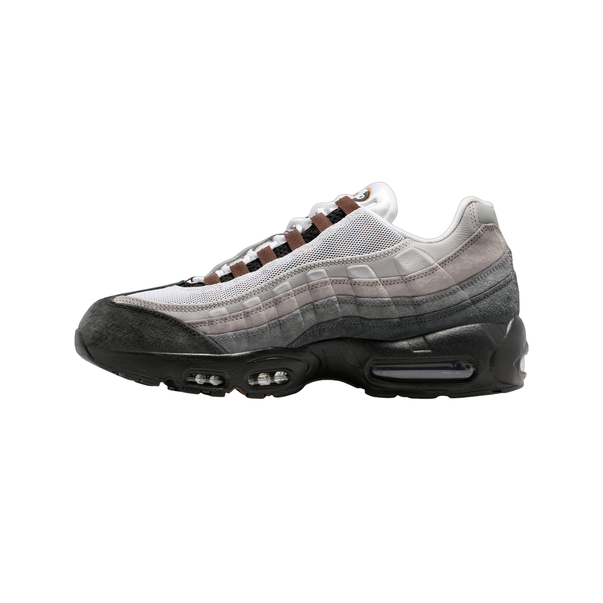 Lateral view of a Nike Air Max 95 sneaker with graduated grey suede panels, white mesh, black toe and heel, visible Air unit in the sole, and brown lace loops with a black patterned lace.