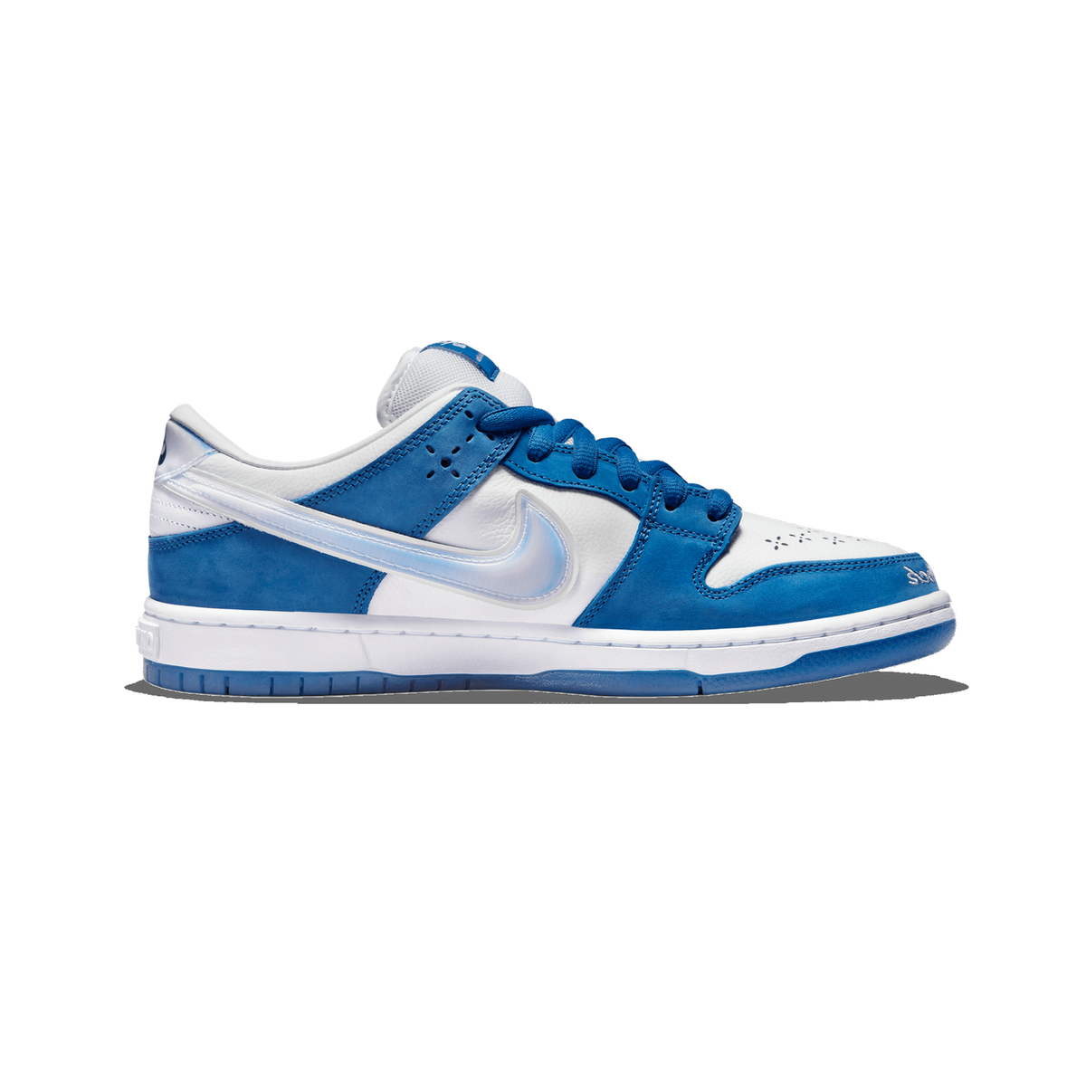 Left Nike SB Dunk Low Born X Raised sneaker shown from the outside with toe pointing left, featuring blue suede overlays, white leather panels, a translucent icy blue swoosh, and a diagonal strap across the midfoot.