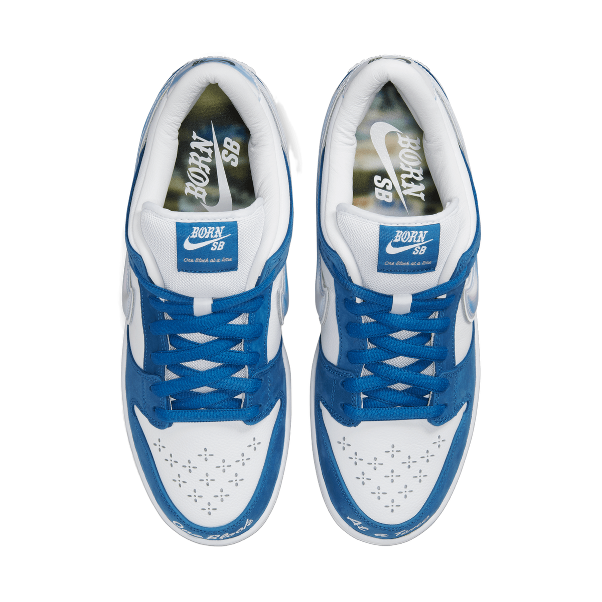 Top-down view of a pair of blue and white Nike SB Dunk Low Born X Raised sneakers with blue laces and Born SB tongue tags, toes pointing downward.