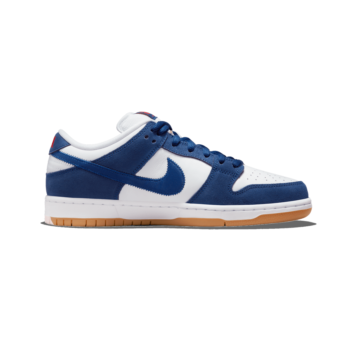 Left Nike SB Dunk Low in white and navy blue with a gum outsole and small red tab on the heel, shown from the side with toe pointing left.