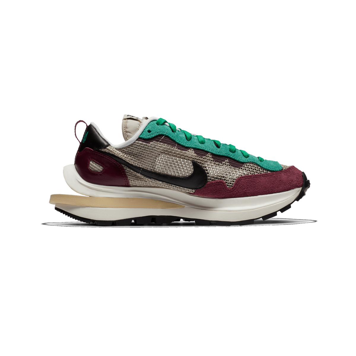 Side profile of a single Nike sacai Vaporwaffle sneaker with the toe pointing left, showing burgundy suede toe and heel panels, green suede and green laces, beige mesh upper with a black Swoosh, and a sand-coloured midsole with a cream outsole.