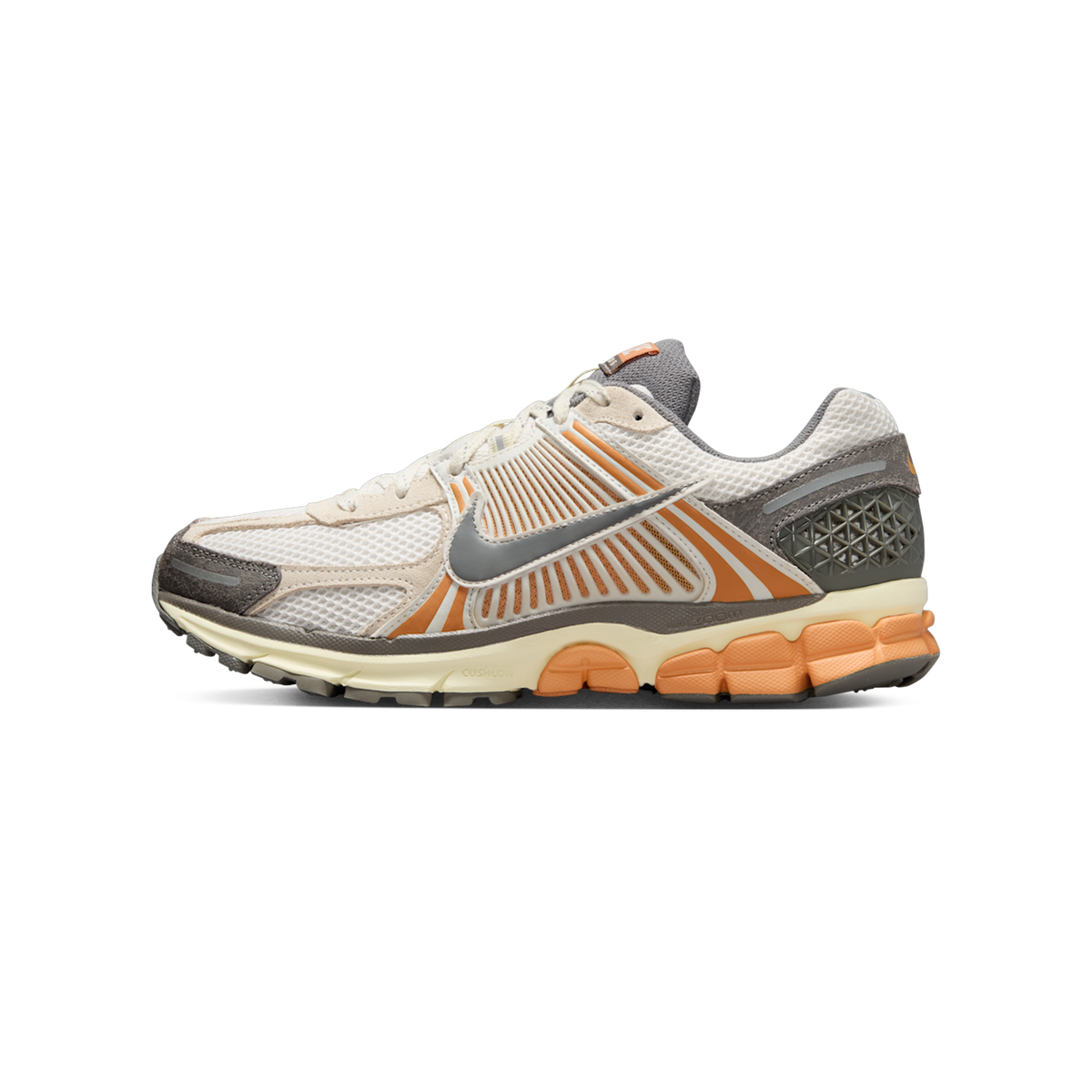 Side view of a white and grey Nike Zoom Vomero 5 sneaker with copper-orange accents and a cream cushioned midsole, toe pointing left