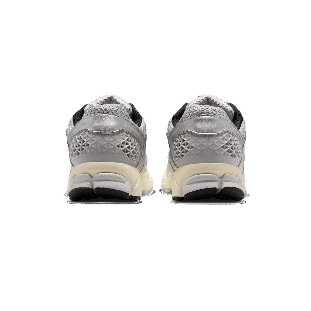 Rear view of a pair of grey and silver Nike Zoom Vomero 5 sneakers standing side by side, showing the heel counters with a metallic silver panel, textured grey heel pods, cream-coloured midsoles and black pull tabs.