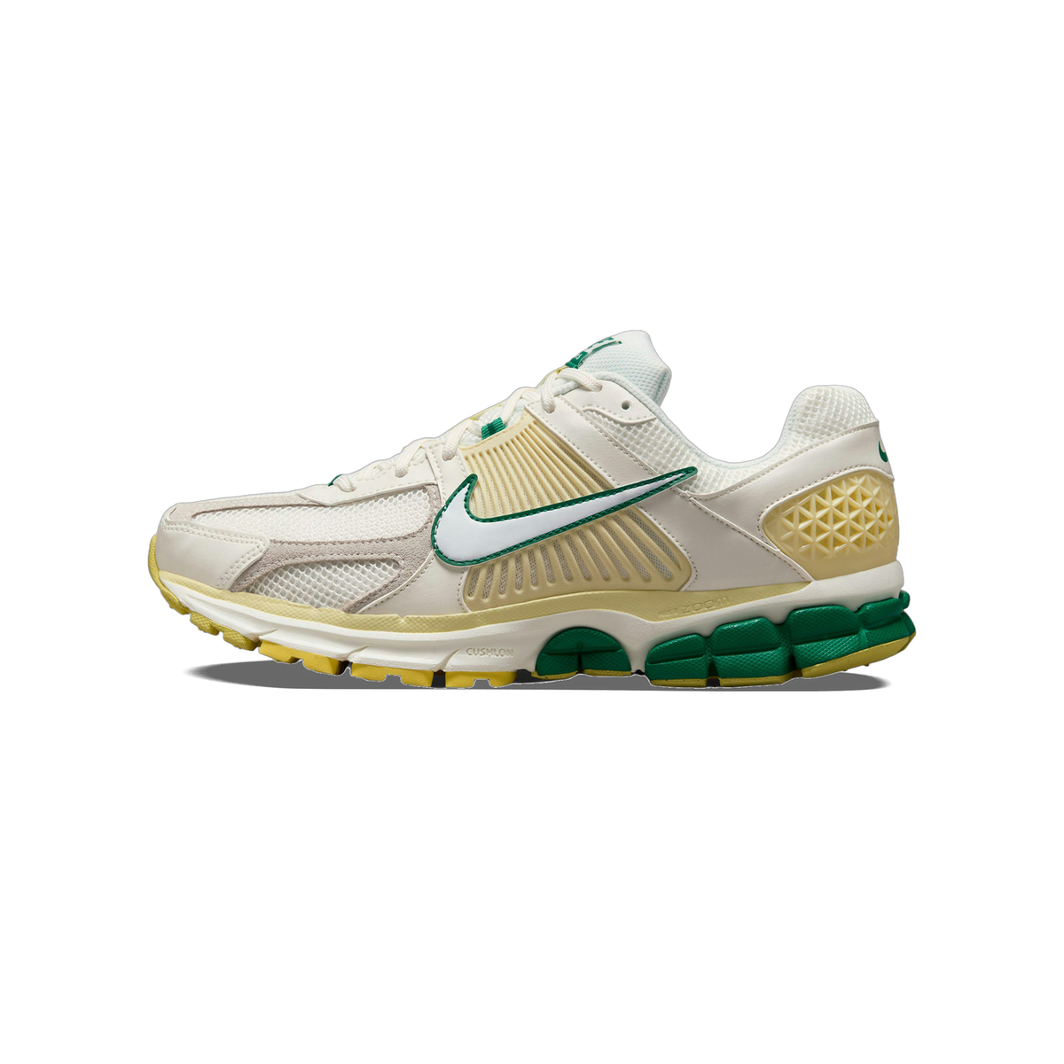 Left side view of a Nike Zoom Vomero 5 sneaker in white and beige with a green outlined swoosh and green and yellow segmented outsole